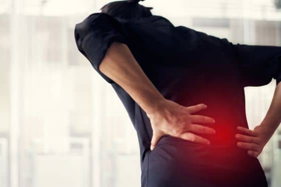 A man doubles over in pain due to back pain