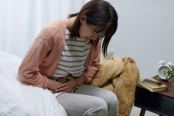 Woman is hunched over with back pain