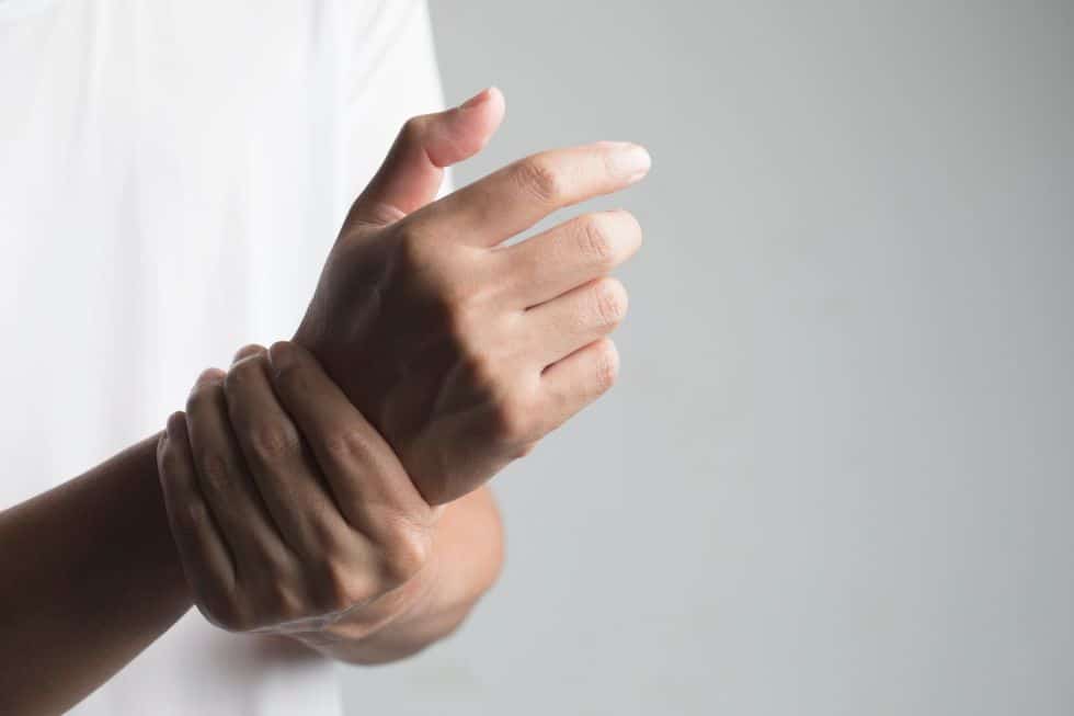 A man suffers from neuropathy pain in the wrist.